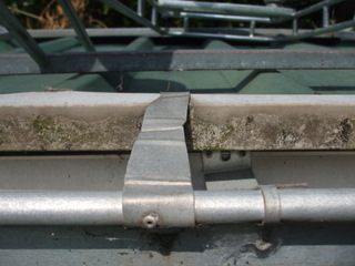 This shot shows a brace, pop rivetted on the roof, curled around the gutter and pop rivetted to the gutter