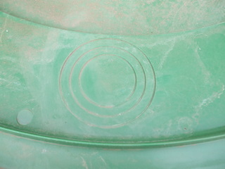A lousy shot of the circular depressions showing where to cut holes in the lid